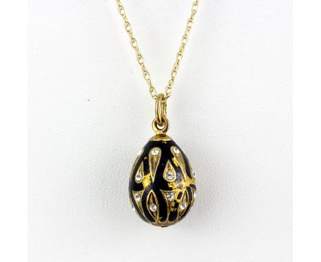 A Russian yellow metal and enamelled egg pendant set with white stones, L. 2.5cm, on a 9ct gold chain.
