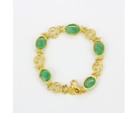 A yellow metal (tested gold) bracelet set with oval cabochon jade, L. 19cm.
