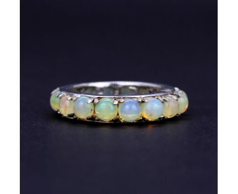 A 925 silver eternity ring set with round cabochon opals, approx. 2.97ct total, (N). With certificate.