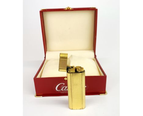A boxed gold plated Cartier lighter.
