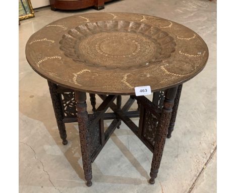 A Benares tray top table on fret and blind carved folding base. 23' diam