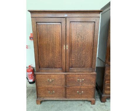 A George III oak linen press, the pair of panel doors enclosing four sliding trays over four doors on bracket feet. 48' w x 7