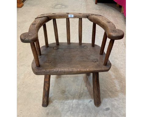 An eighteenth century Welsh primitive oak elbow chair with stick back on splayed legs