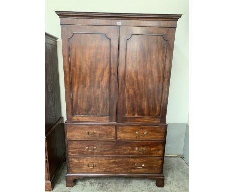 A George III mahogany press, the pair of doors enclosing hanging space, over two false drawers and two long drawers, on brack