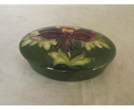 Moorcroft Pottery - a covered oval trinket box decorated with honeysuckle on a green ground, 4 cm x 13 cm x 9 cm - Est £40 - 
