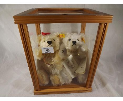 Steiff bears - a glazed display case containing two Steiff bears, Monday's Bear and Tuesday`s Bear, each with button in ear, 
