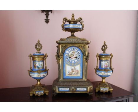 Late 19th century French gilt metal three piece clock garniture, the clock with urn finial and "Sevres" blue ground panels of