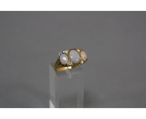 A MODERN OPAL AND DIAMOND GYPSY STYLE RING, scroll engraved sides and shoulders, total modern round brilliant diamond weight 