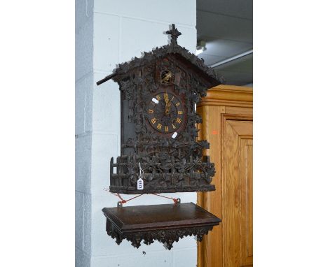 A LATE 19TH CENTURY BLACK FOREST STYLE CARVED OAK CUCKOO CLOCK, twin fusee movement, ornately decorated with fruiting vine, b