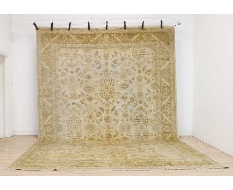 A wool carpet of Persian Ziegler design, of recent manufacture, Afghan, woven with Shah Abbasi motifs to a pale ground,436 x 