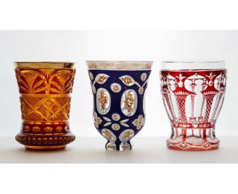 A group of Bohemian glass beakers,comprising a 'Souvenir' glass, c.1840, double-cased over amber and cut with fan motifs, wit