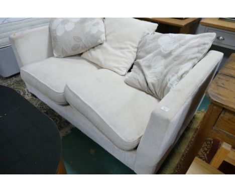 Cream upholstered two seater sofa bed / settee with floral cushions