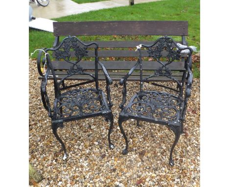 A hardwood slatted garden bench with wrought iron end supports, together with two cast iron garden chairs