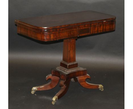 A Victorian mahogany fold-over card table on single square section tapering column, to quatrefoil base, the legs terminating 