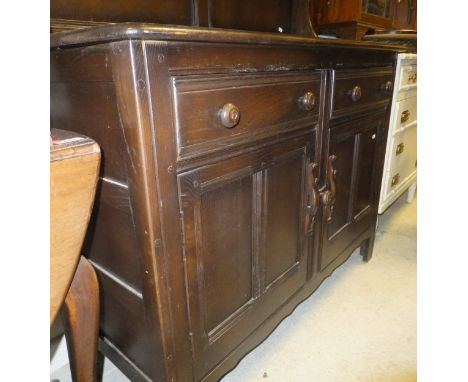 An Ercol oak dresser, the two tier plate rack above two drawers and two cupboard doors