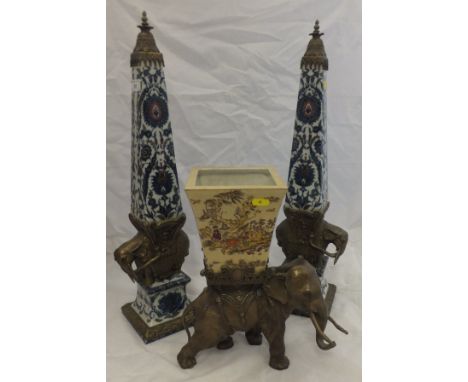 A pair of Indian brass and floral decorated porcelain columns, standing on the back of a brass elephant, to a porcelain and b