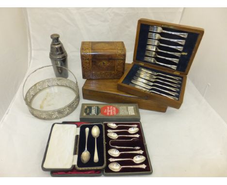 A cased set of six silver teaspoons with sugar tongs, a cased pair of silver spoons, two oak cased fish knives and forks, and