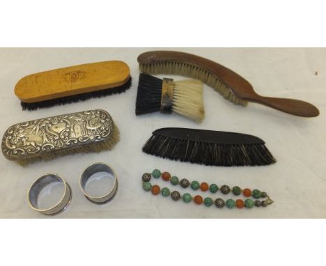 A box containing a carved amber and jade and white metal beaded necklace, together with a silver backed brush embossed with b