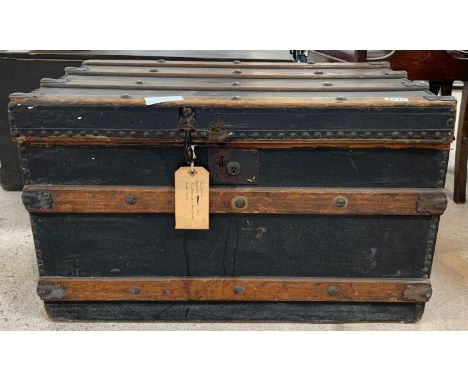 A late 19th/early 20th Century wooden travelling trunk, having painted canvas covering, metal bound and with wood slats and s