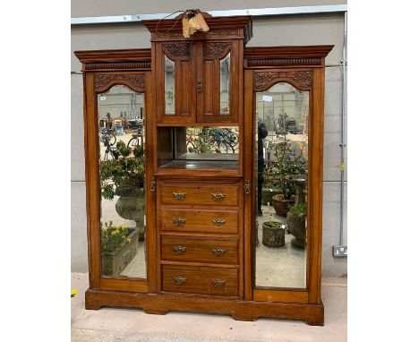 A late Victorian/Edwardian red walnut compactum having side hanging compartments the doors fitted with bevelled glass, the ce