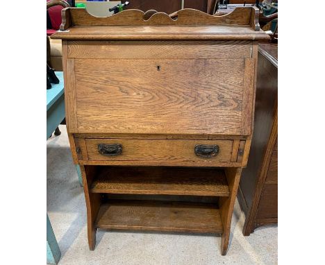 A small early 20th Century oak bureau of Arts and Crafts style the fall flap enclosing pigeon holes, fitted with single drawe
