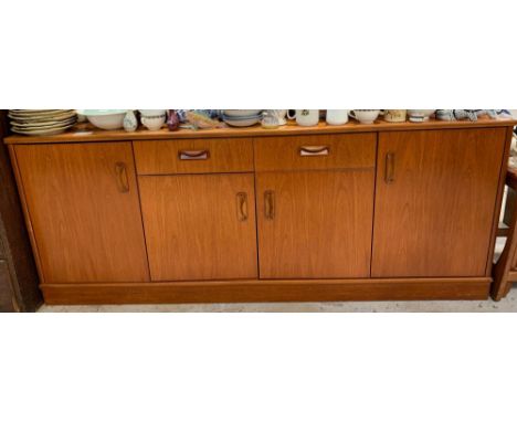 A teak G-Plan sideboard, mid-20th century, with single long cutlery drawer flanked by a cupboard to each side, each with a si