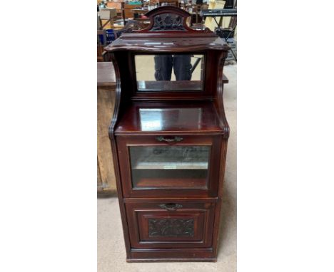 A Victorian mahogany music cabinet, with raised carved top, below this an open shelf with mirrored back, leading to fall fron