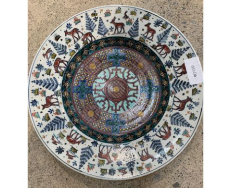 A heavily decorated large low charger, possibly Scandinavian, the centre with geometric patterns, circles and crosses in enam