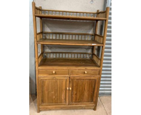 A 20th century pine storage unit, the top with three open shelves and spindle supports, the base with two short drawers above