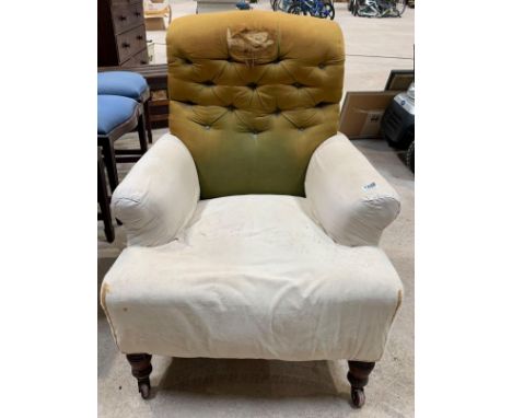 A Victorian upholstered easy chair having button back and turned front supports, on original casters. Viewing/collection at W