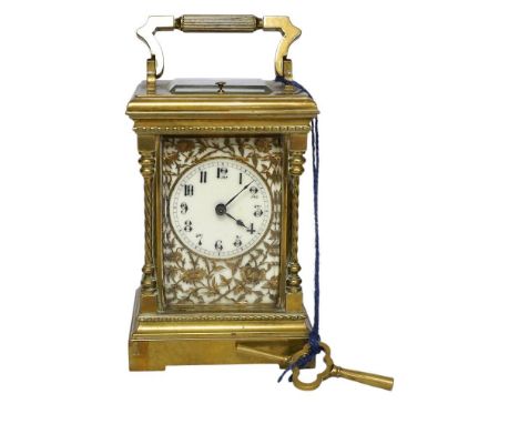 A large brass repeating carriage clock with key and ornate filigree dial, 17cm high (including handle). Condition - good, unc