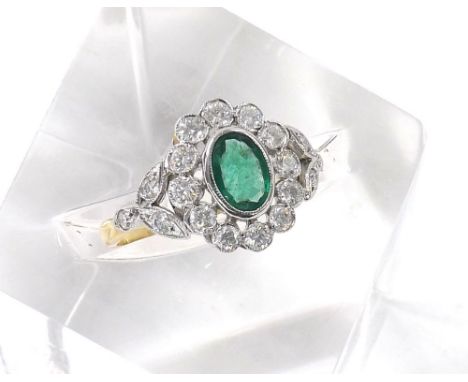 Antique style 18ct oval emerald and diamond ring, the emerald estimated 0.85ct in a diamond surround with foliate shoulders, 