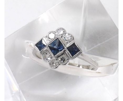 18ct white gold sapphire and diamond dress ring in the Art Deco manner, with a row of three sapphires in a surround of six mi