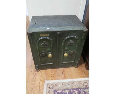 A RECTANGULAR METAL FLOOR SAFE, the green painted frame with a pair of arched panelled doors with metal lock plates engraved 