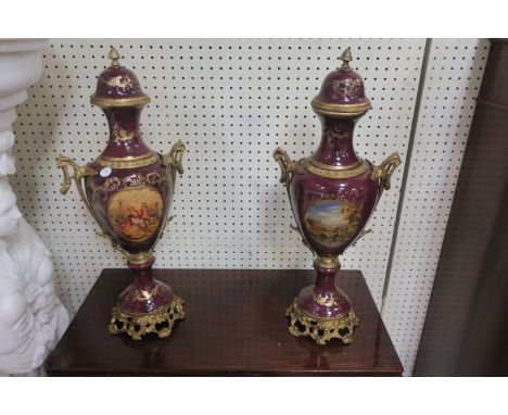A PAIR OF CONTINENTAL STYLE GLAZED PORCELAIN AND GILT BRASS MOUNTED URNS, of typical form the domed lid with raised finial, t