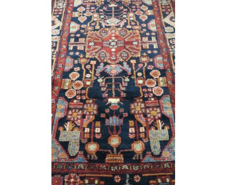 A HAMADAN WOOL RUG, the wine, black, light blue and beige ground with central panel within a conforming border, 270cms x 154c