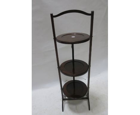 AN EARLY 20TH CENTURY MAHOGANY THREE TIER CAKE STAND, the rectangular frame fitted with three circular plates on splayed supp