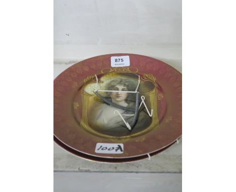 A PAIR OF ORIENTAL PORCELAIN PLATES, each with a puce and gilt ground, with portrait panels, 25cms diameter.