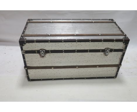 A METAL AND WOODEN FRAMED TRUNK, of typical form with chrome studs and leather borders, 53cms x 100cms x 49cms 