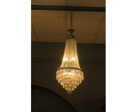 A CUT GLASS AND GILT BRASS CENTRE LIGHT, hung with cascading facetted pendants above a six tier circlet hung with pendant dro