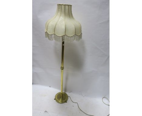 A MODERN BRASS FRAMED STANDARD LAMP, with cream padoda shaped panelled shade with foliate braid and fringing, 168cms high.