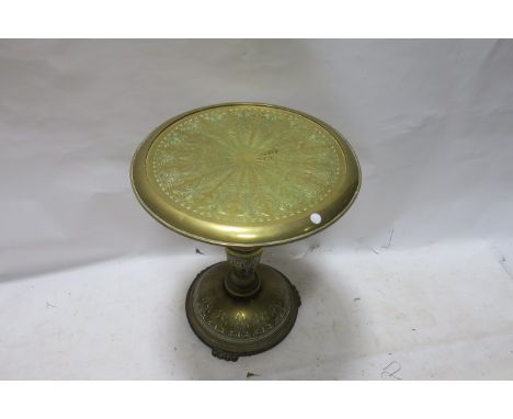 AN EMBOSSED BRASS OCCASIONAL TABLE, the circular top with foliate filled panel raised on a waisted column support with domed 