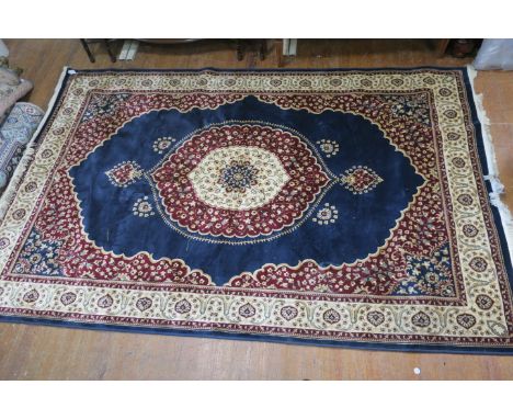 A WOOL AND SILK RUG, the dark blue and beige ground with central floral panel within a conforming border,290cms x 190cms.