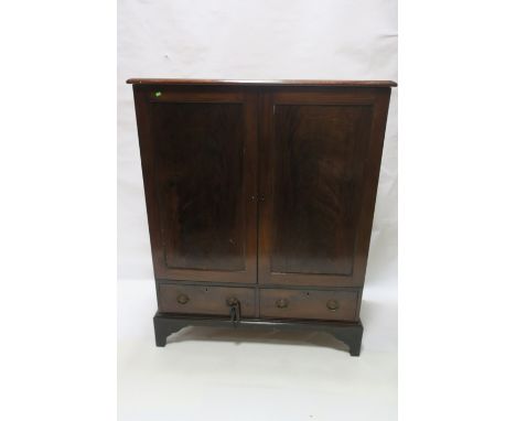 A GEORGIAN MAHOGANY LINEN PRESS, with panelled doors containing slide shelves, the base with two short drawers on bracket fee