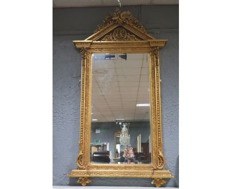 A FINE CONTINENTAL GILTWOOD AND GESSO MIRROR OF ARCHITECTURAL OUTLINE, the rectangular bevelled glass plate within a C scroll