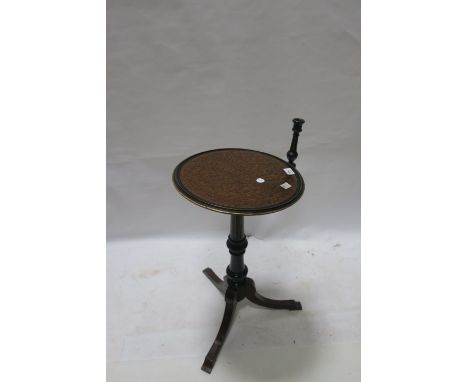 AN EDWARDIAN EBONISED AND BURR WALNUT READING TABLE WITH CANDLESTICK ON TRIPOD SUPPORT, the circular dished top with candleho