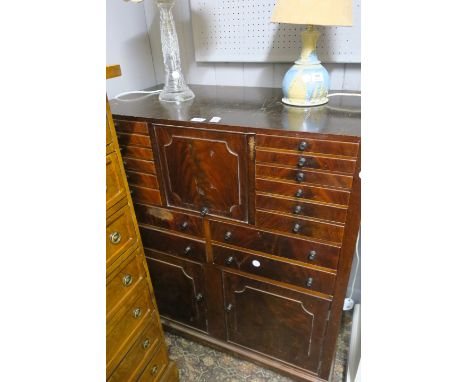 A MAHOGANY SPECIMEN CHEST, the rectangular top with hinged compartment and an arrangement of sixteen drawers above a pair of 