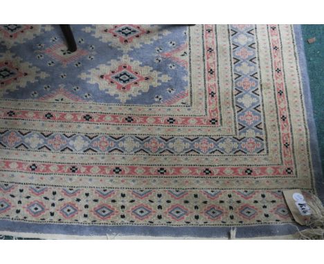 A WOOL RUG, the light blue and beige ground with central diamond panels within a conforming border,2454cms x 180cms.