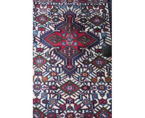 A PERSIAN BIRJAND RUNNER, the central cream panel with a band of red and royal blue geometric motifs, flanked by multiple con