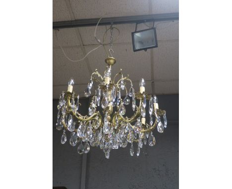 A CONTINENTAL STYLE GILT FRAMED EIGHT LIGHT CHANDELIER, scrolled arms issuing a acanthus and hung with pendant dropsThe purch